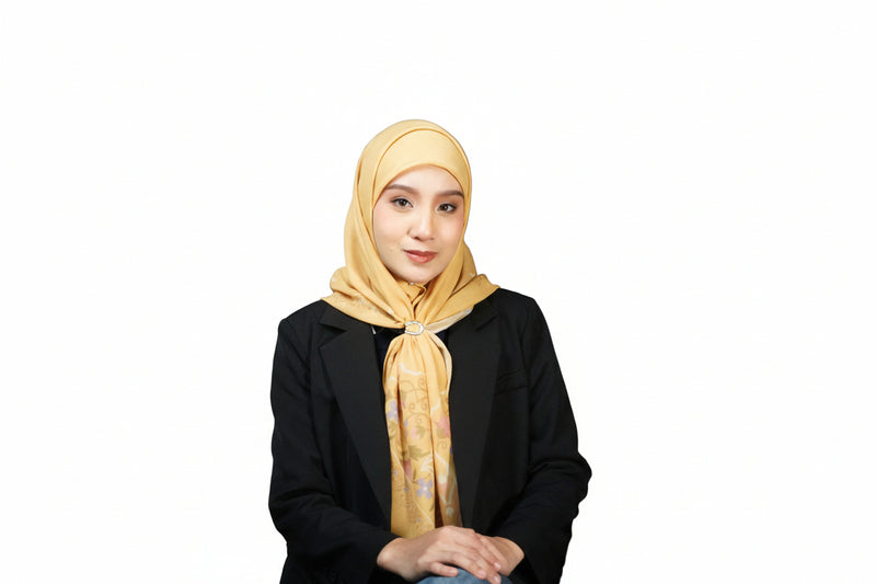 Woman wearing a yellow hijab and black outfit against a gray background